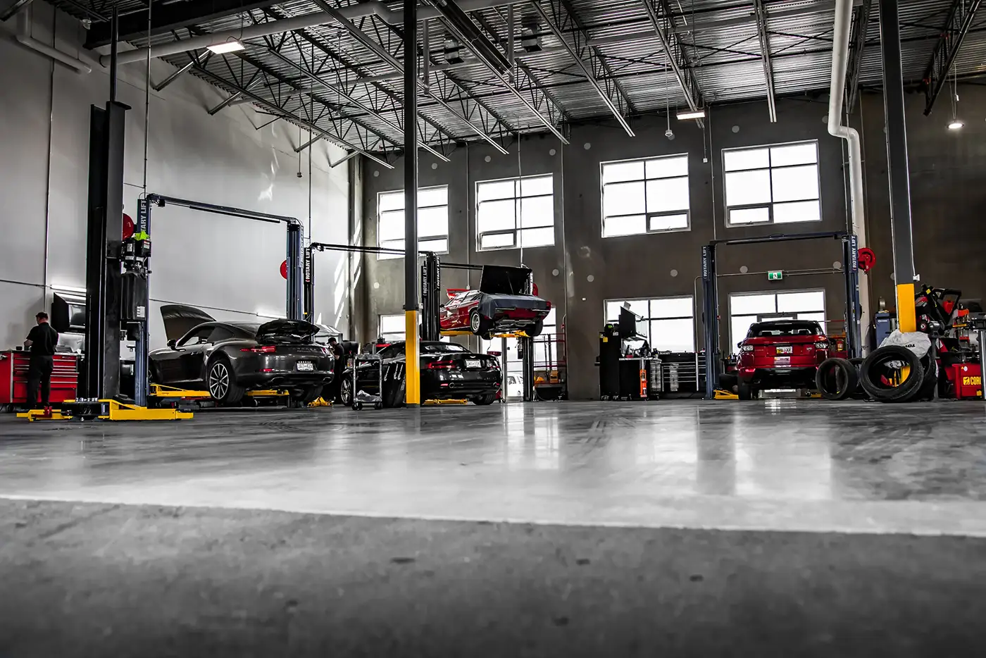 Cars on lifts inside a busy auto repair shop